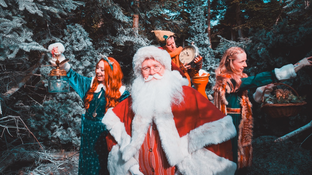Father Christmas and the residents gathered among the snowy trees of Nollaig