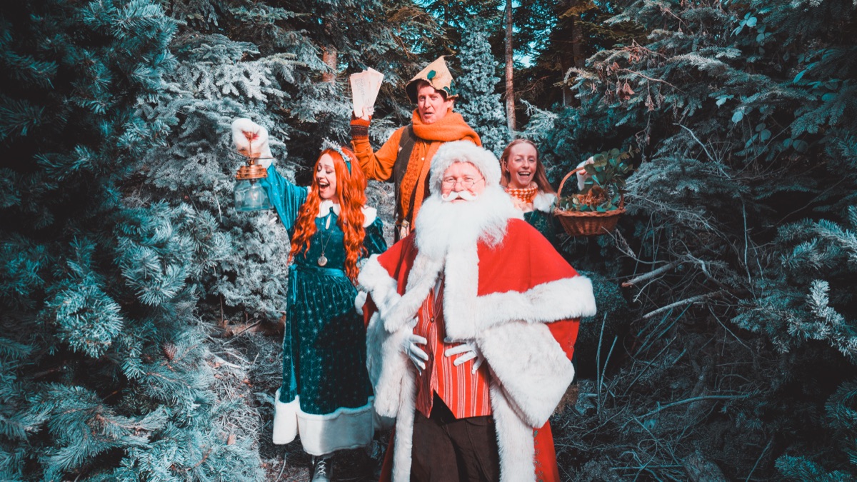 The residents of Nollaig raising letters and a lantern beside Father Christmas